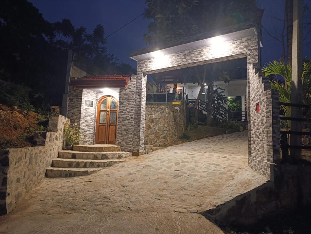 a stone house with a door and stairs at night at Zion Haven Villa in Tangalle