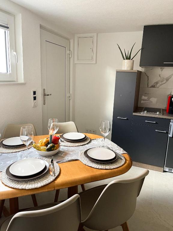 a dining room table with plates and wine glasses at Ferienwohnung Alecasa in Gailingen
