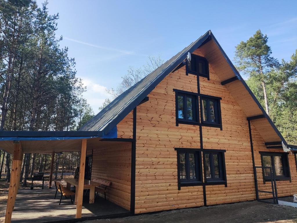 a log cabin with a blue roof at Duży dom w lesie in Zatory