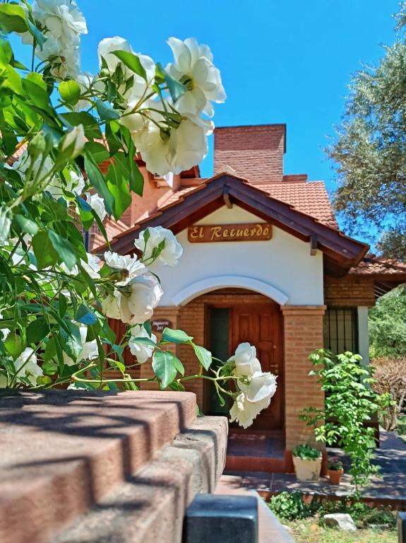 a building with white flowers in front of it at El Recuerdo in Merlo