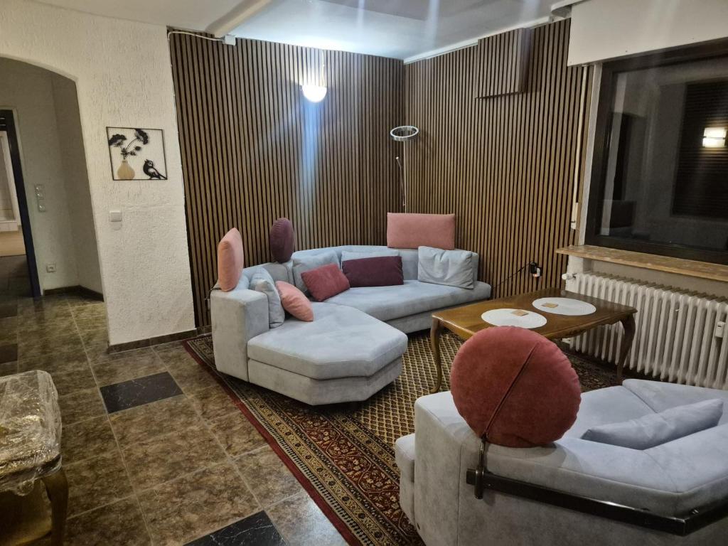 a living room with couches and chairs and a television at Waterloo Sunset Hotel in Erzhausen