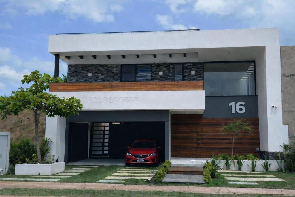 a red car parked in the garage of a house at Tamaran casa de playa Pescadores 16 in Cruz de Huanacaxtle