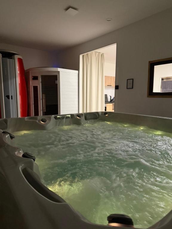 a jacuzzi tub with green water in a room at Instant Charnel Sauna et Jacuzzi Privatif in Istres