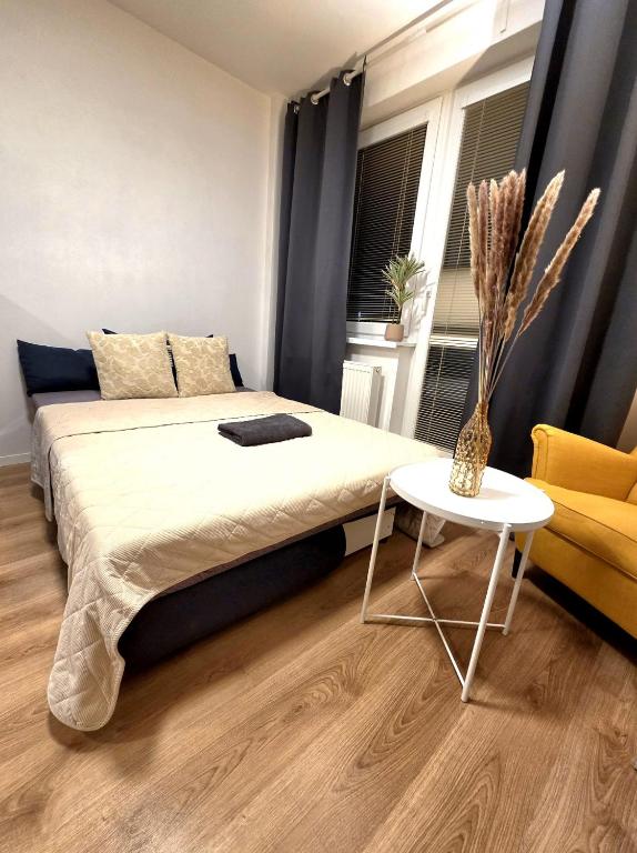a bedroom with a bed and a table and a chair at Apartmán Bratislava Ružinov in Nivy