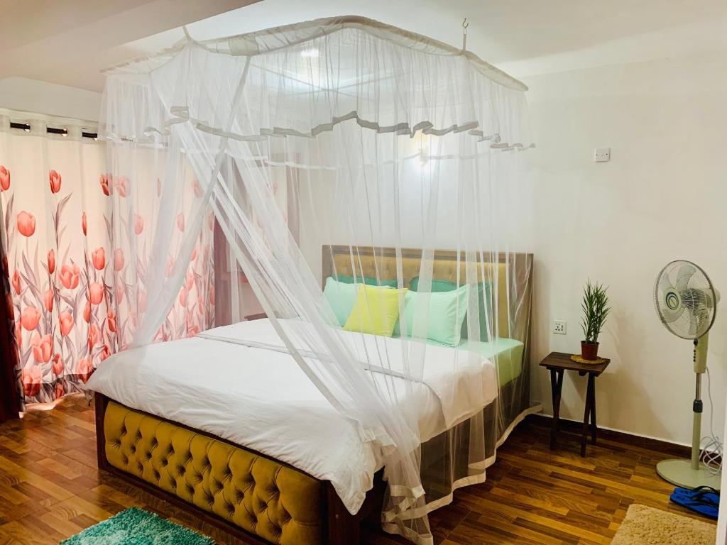 a bedroom with a canopy bed with white curtains at Happy Rest House Ella in Ella