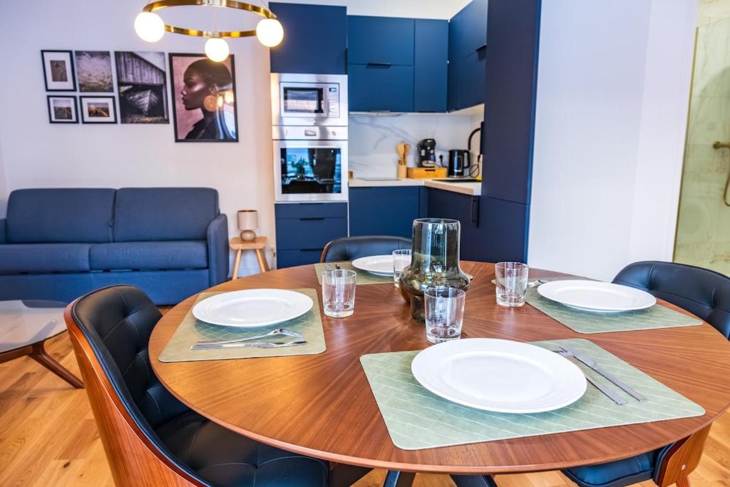 a dining room table with white plates on it at Studio Élégant - Proche Paris & La Défense in Rueil-Malmaison