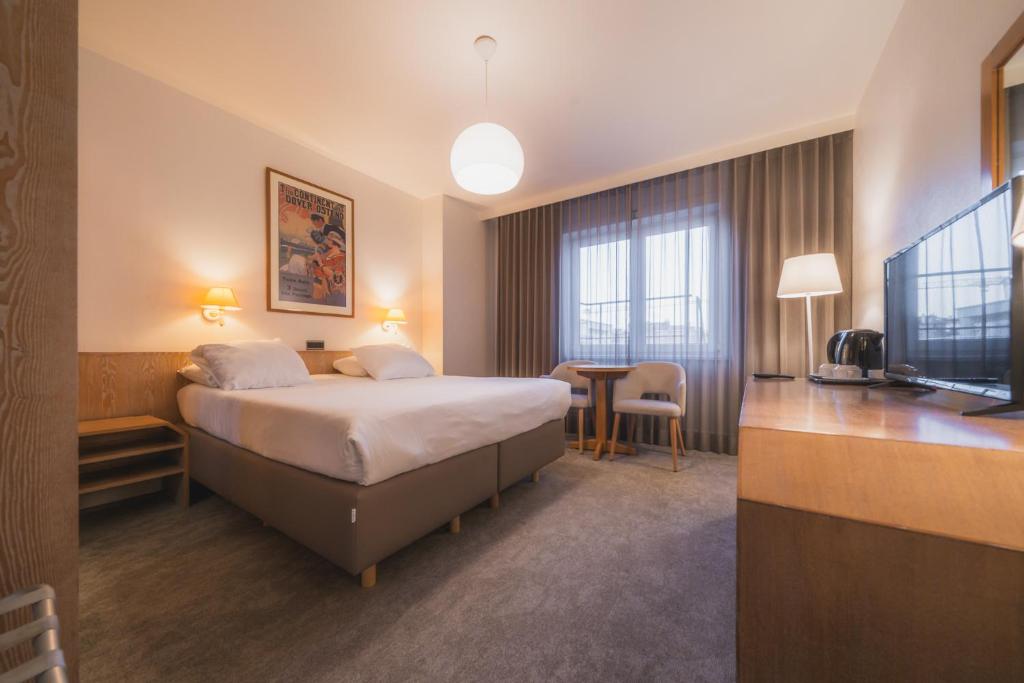 una stanza d'albergo con un letto e un tavolo di Hotel Prado a Ostenda