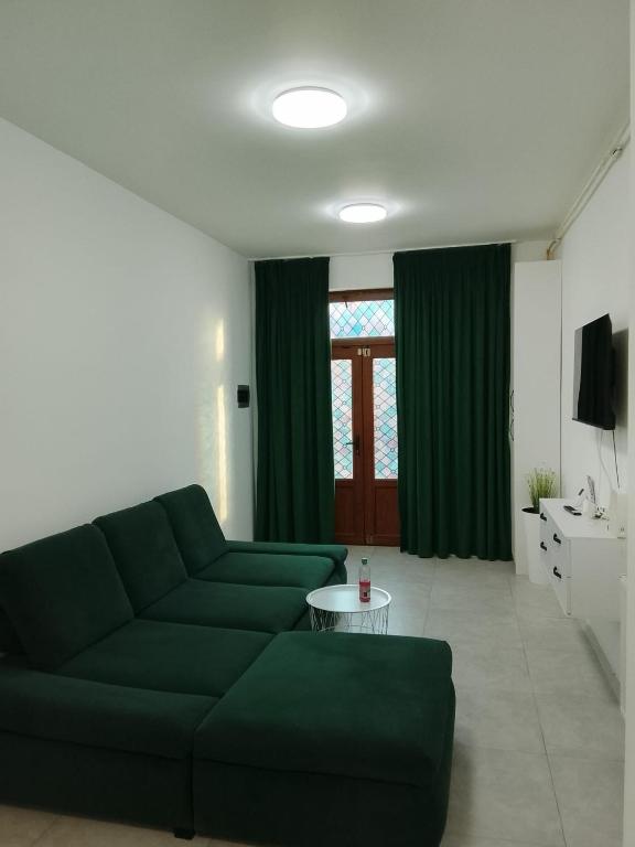 a living room with a green couch and a table at Focsani Casa cris in Focşani
