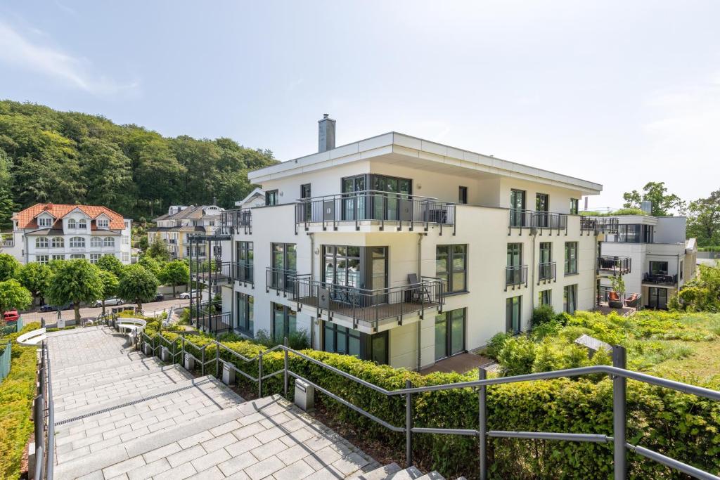 a large white house with a walkway in front of it at Villa Louisa - Wohnung 36 in Ostseebad Sellin