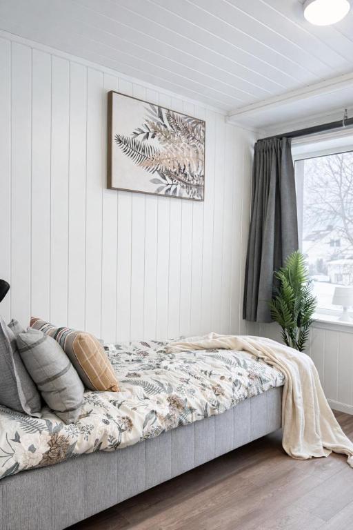 a bedroom with a bed with a picture on the wall at Rygge Apartments in Moss