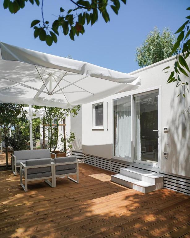 a house with a patio with a white umbrella at Otium Mare Felix in Stazione di Paestum