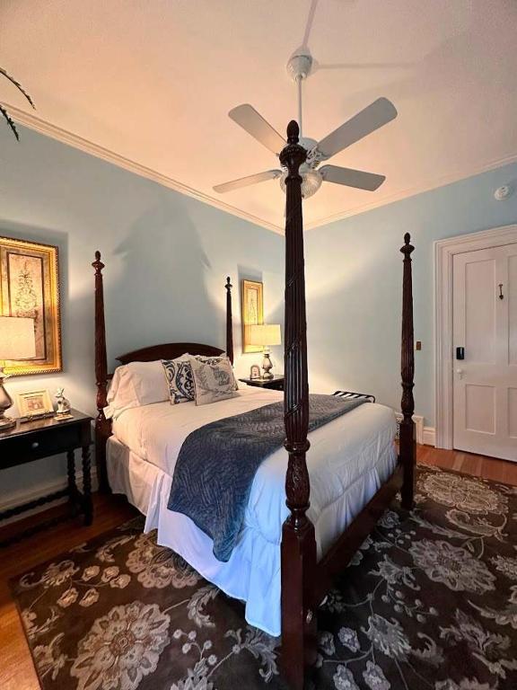 a bedroom with a bed with a ceiling fan at Bluebell Room in Oswego
