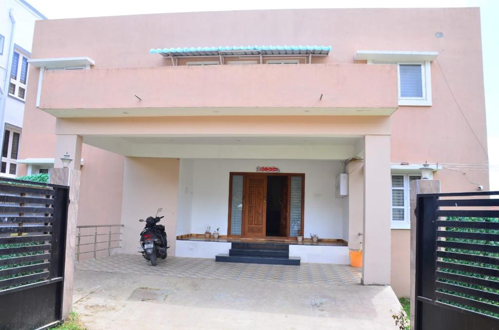 a pink house with a motorcycle parked in front of it at Redfox Villa - Kodaikanal in Kodaikānāl