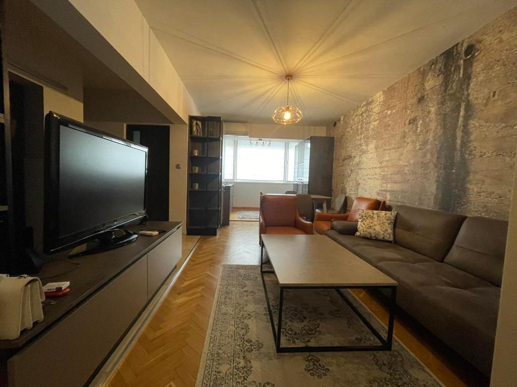 a living room with a couch and a tv at Катедрала Варна in Varna City