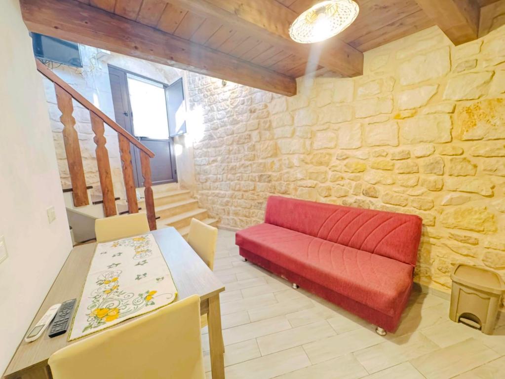 a living room with a red couch and a table at B&B Mairè in Scicli