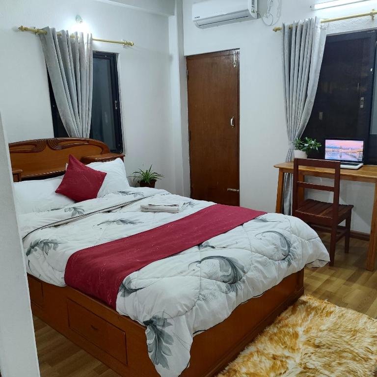 a bedroom with a bed and a desk and window at North face Studio in Pokhara