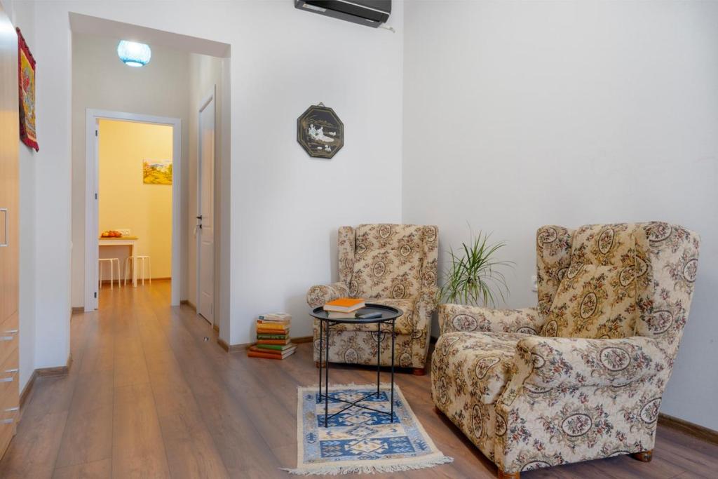 a living room with a chair and a table at Avgarose in Itʼkhvisi