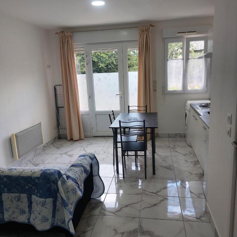 eine Küche und ein Esszimmer mit Tisch und Stühlen in der Unterkunft forgestudio in Saint-Bômer-les-Forges