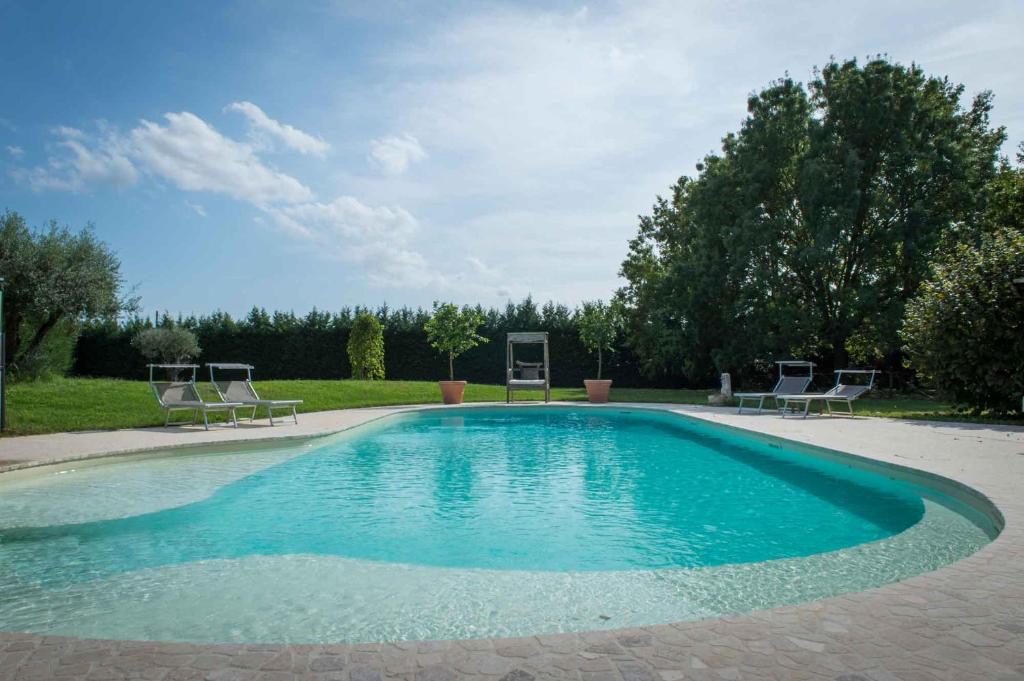 a large swimming pool with two chairs around it at Casa Cardinala in Gambellaro