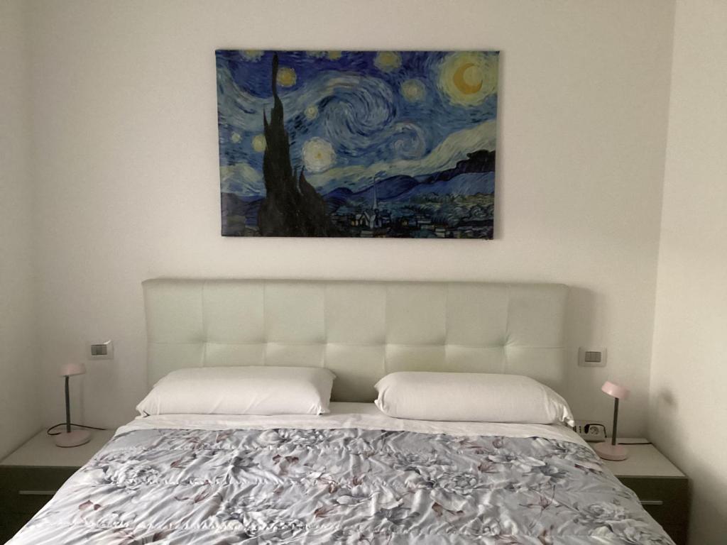 a bedroom with a bed with a painting above it at Bed and Breakfast da Giuseppe, Camere vicino stabilimento Ferrari in Fiorano Modenese