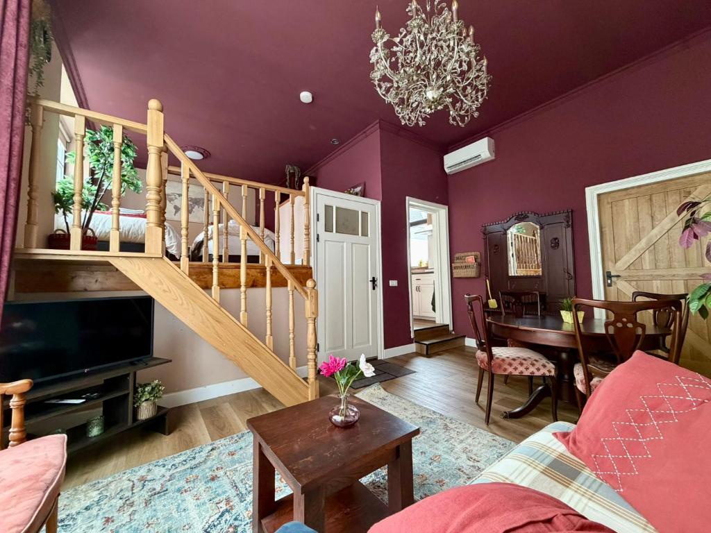 a living room with purple walls and a staircase at B&B Schipperspad in Tolkamer