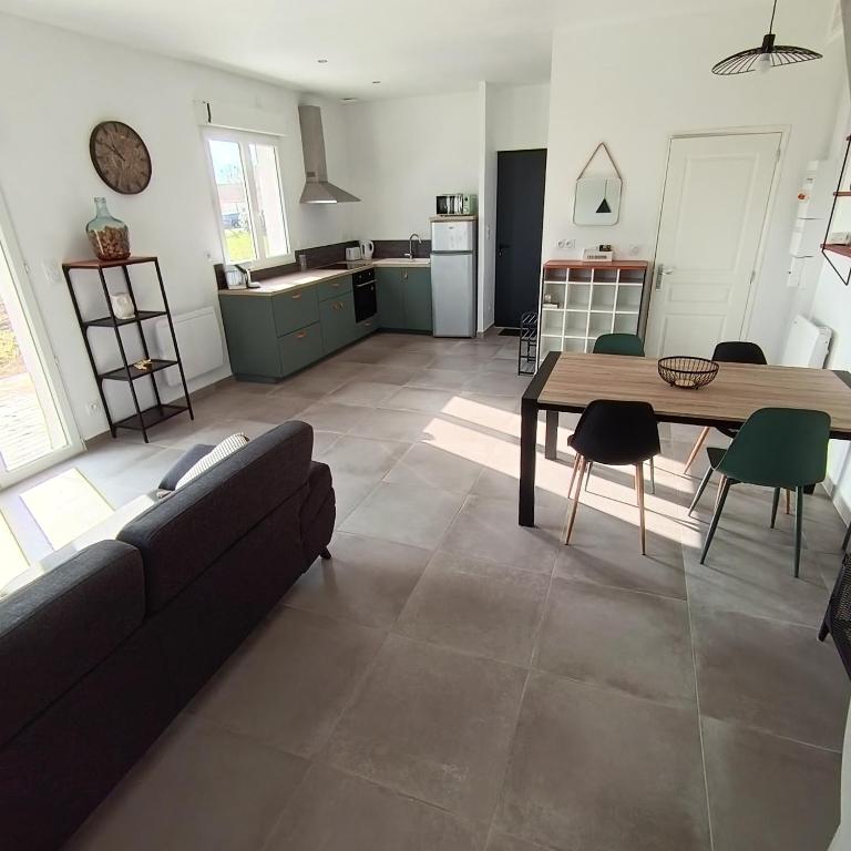 a living room with a couch and a table at Logement 2 - proche Le Mans in Aigné
