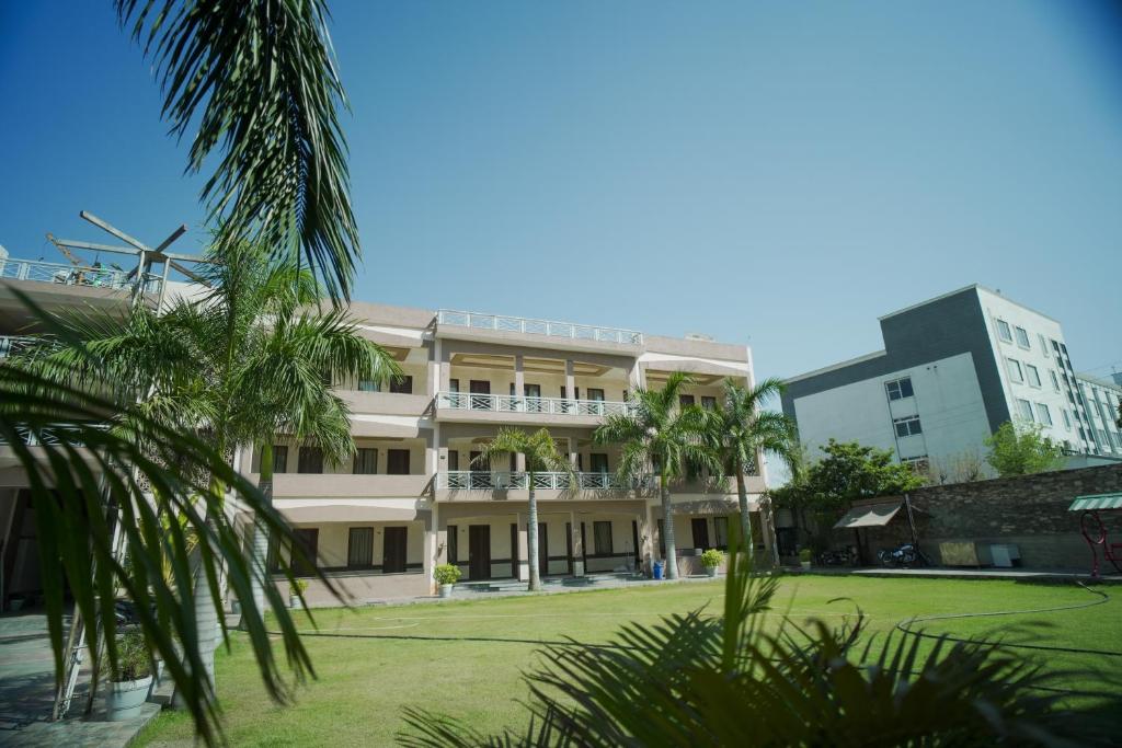 a building with palm trees in front of it at Rani Palace Hotel And Resort in Kishangarh