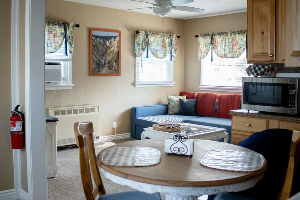 a living room with a table and a blue couch at Our Little Yellow House in Saint Anthony
