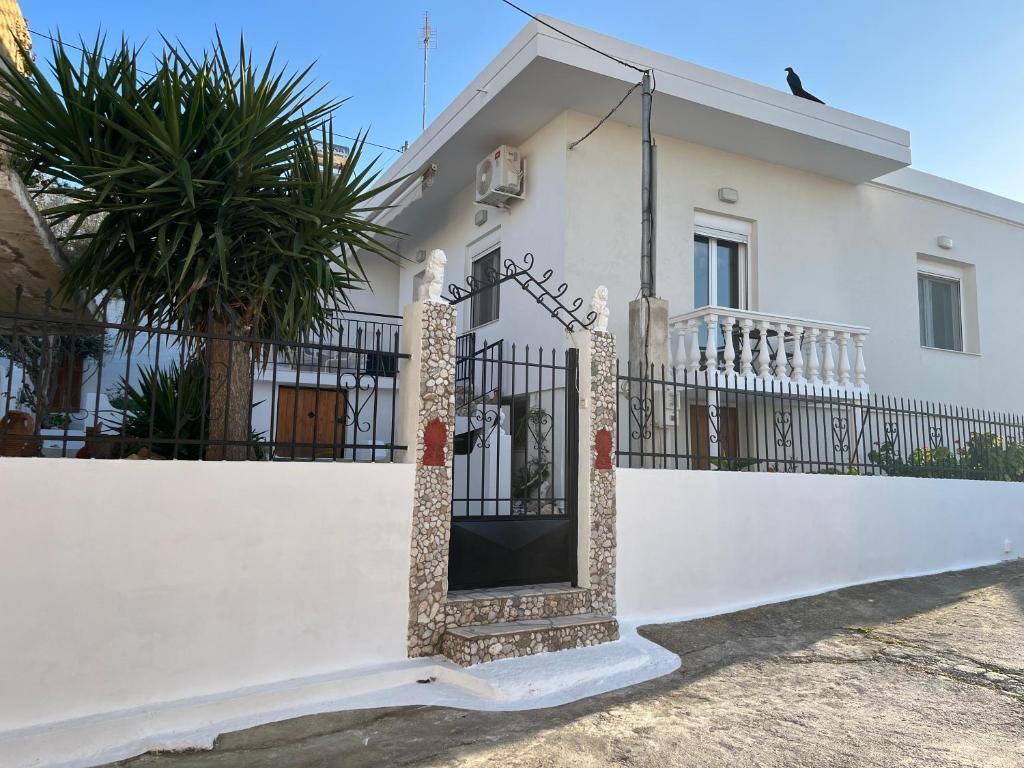 a white house with a gate and a fence at The White House - Aianteio in Aiándion