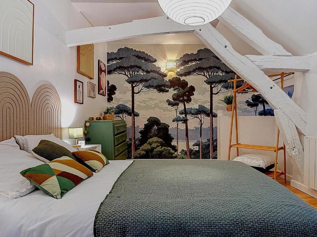 a bedroom with a bed with a mural of trees at La Courette des Rois - Hyper centre & Chateau in Dourdan