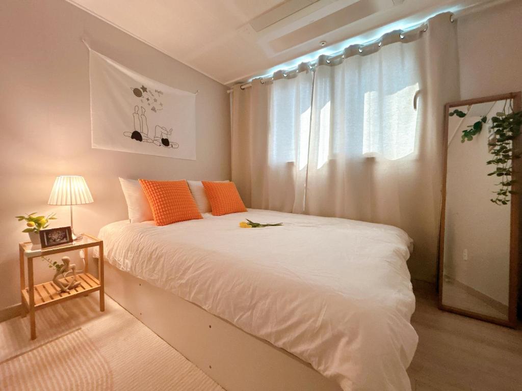 ein Schlafzimmer mit einem weißen Bett und einem Fenster in der Unterkunft Gate 303 in Seoul