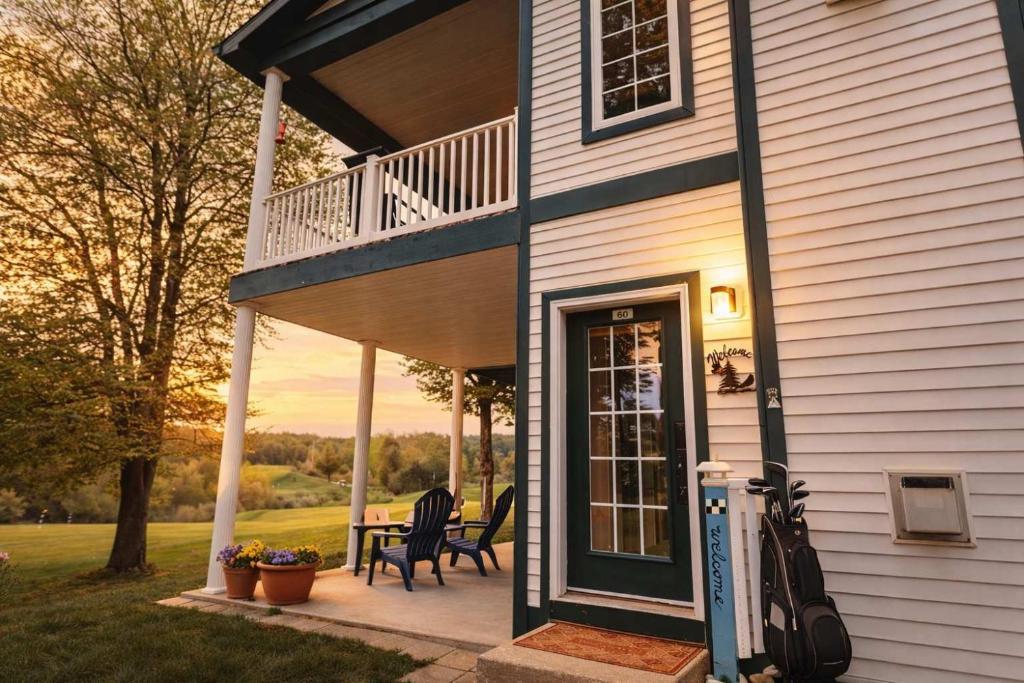 a front porch of a house with a table and chairs at Picturesque Condo perfect for Golf, Families, Pools and Lake vacation in Bellaire