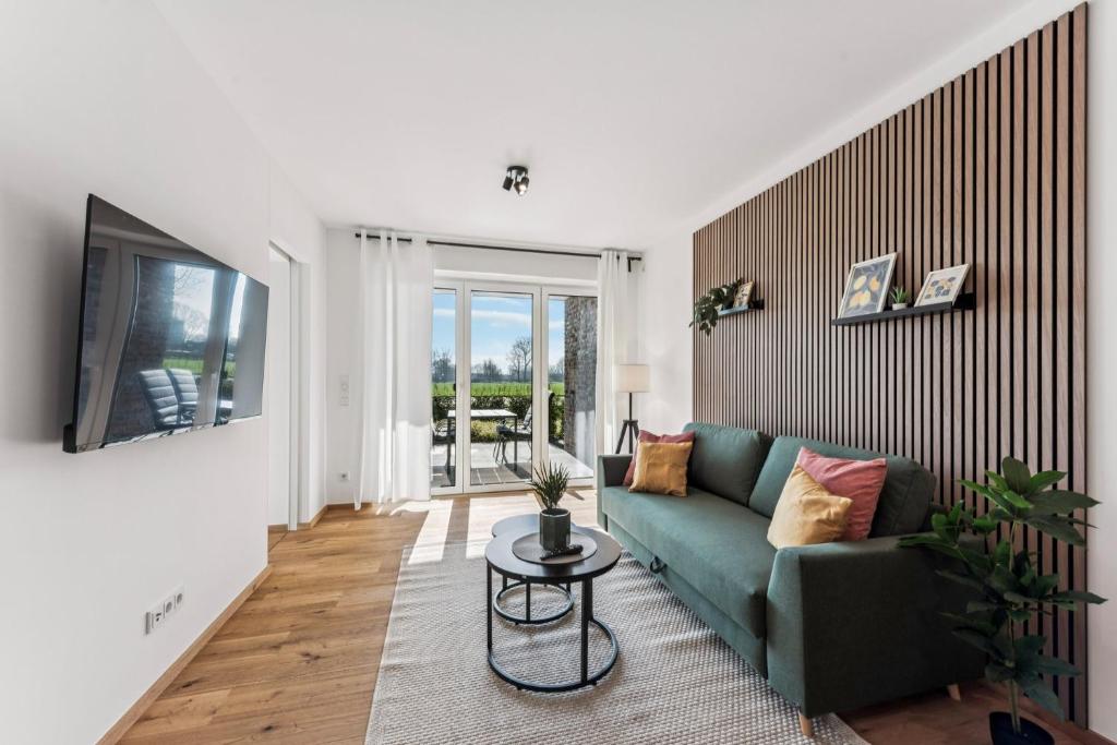 a living room with a green couch and a table at BohnApartments Dümmer See Suites, Top Lage 350 m zum See, Balkon, WLAN, Parkplatz in Lembruch