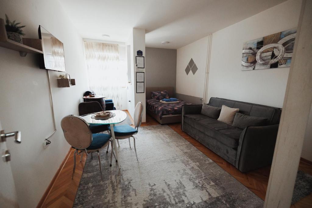 a living room with a couch and a table at LUX Apartman Jugi PARKING public free in Novi Pazar