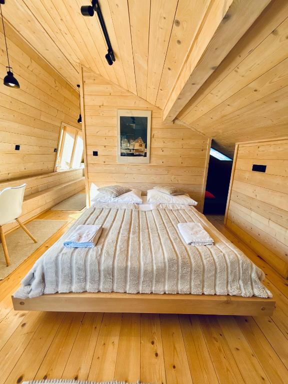 a bedroom with a bed in a wooden room at Apartament Widoknastok in Korbielów