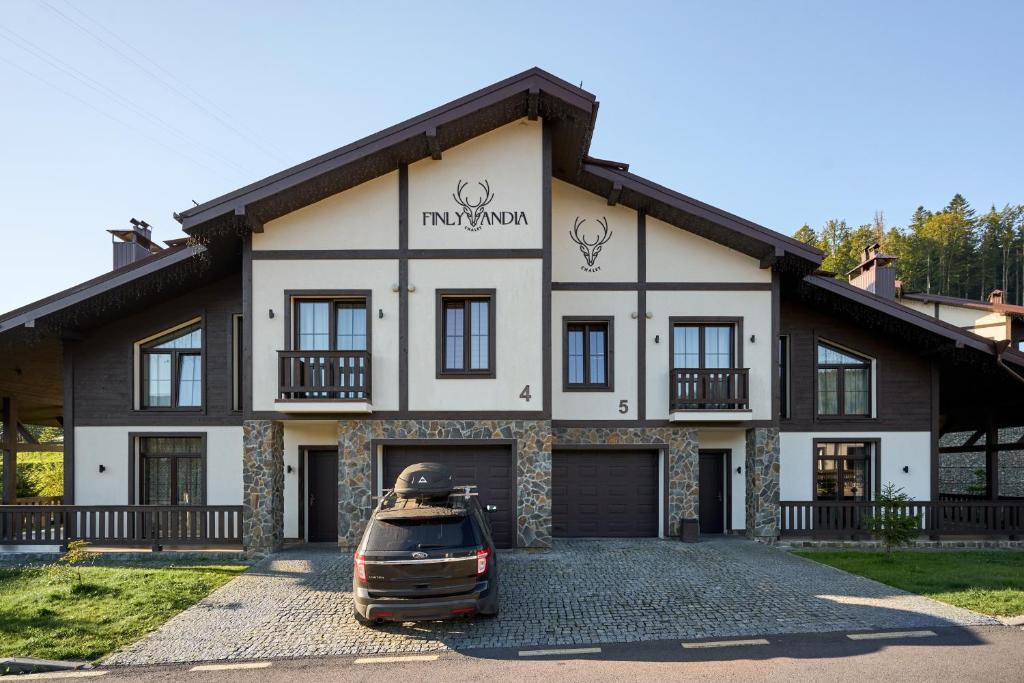 a house with a car parked in front of it at Finlandia Chalet in Bukovel
