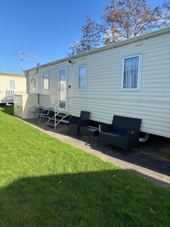 a mobile home with two chairs and a table at Haven Caravan Park Cala Gran 3 bedrooms Fleetwood in Fleetwood