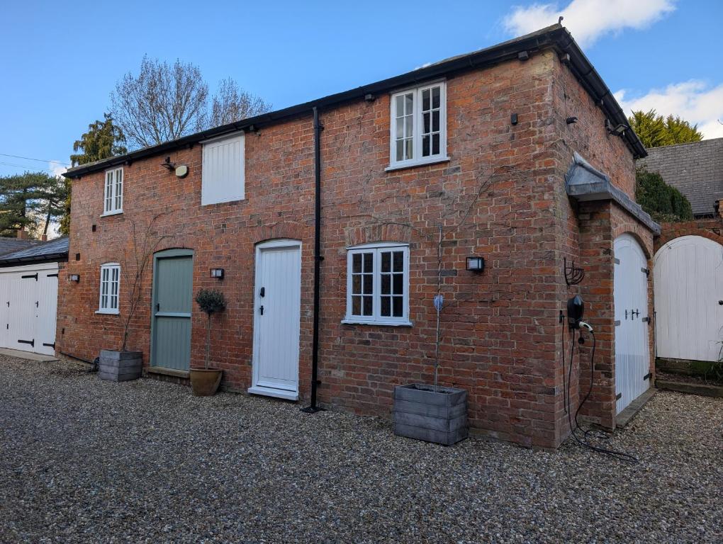 a red brick building with white doors and windows at Worlaby Coach House in Worlaby
