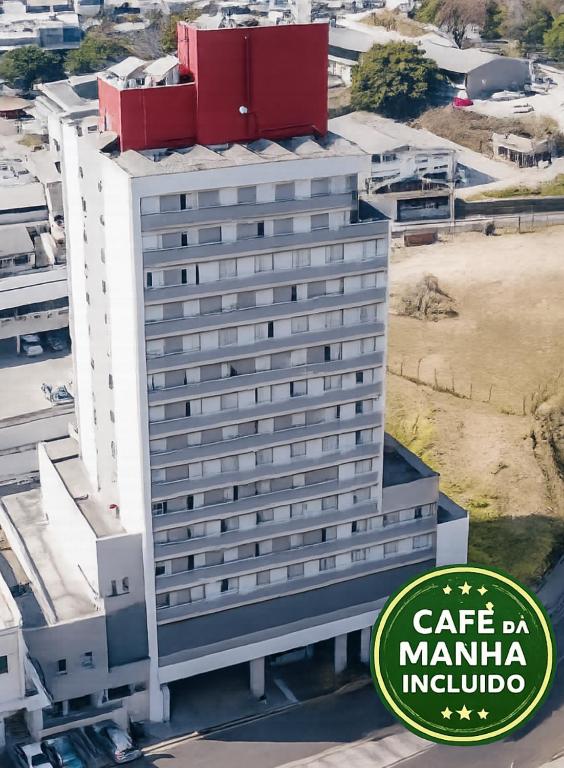 a tall white building with a red roof at Stop Inn Antonio Carlos in Belo Horizonte