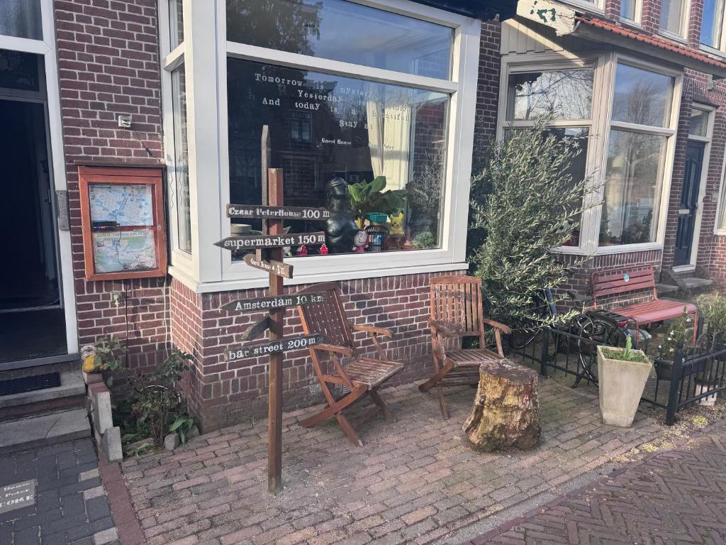 a street sign in front of a building with two chairs at Guesthouse Czaar Peter in Zaandam
