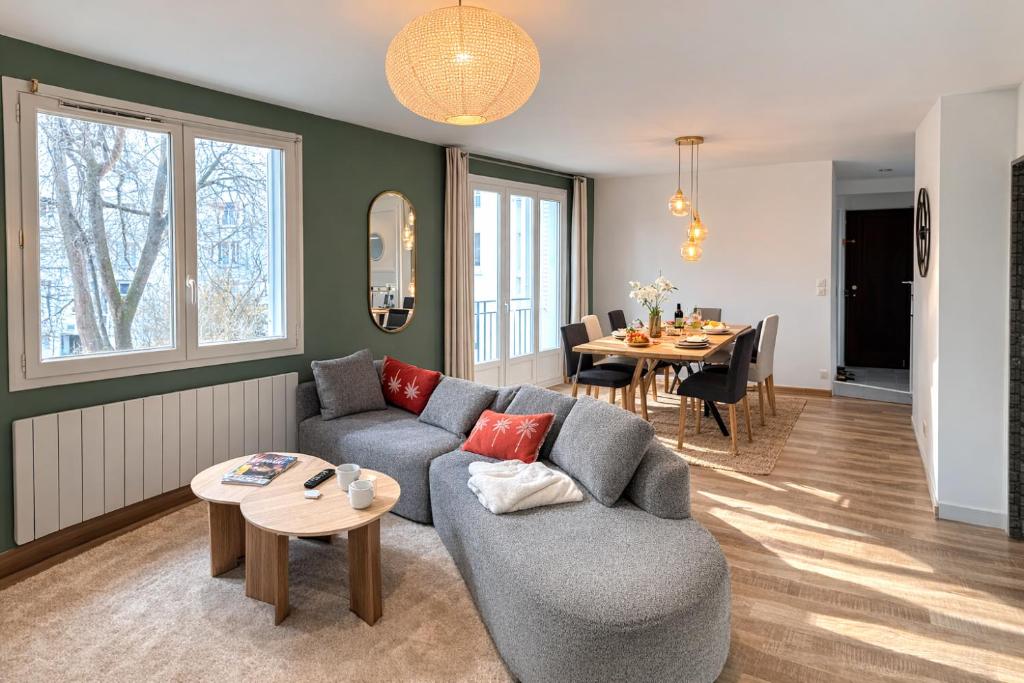 a living room with a couch and a table at Le Robespierre - Parking privé - 5min gare in Reims