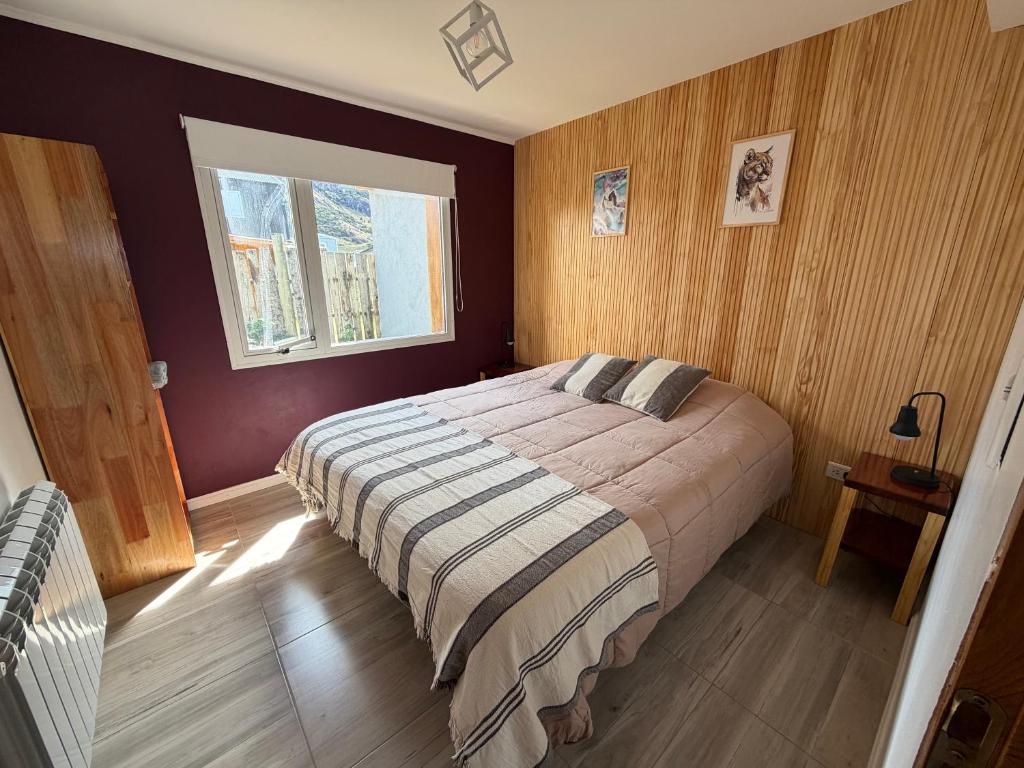 a bedroom with a bed and a window in it at Nomade Aparts in El Chalten