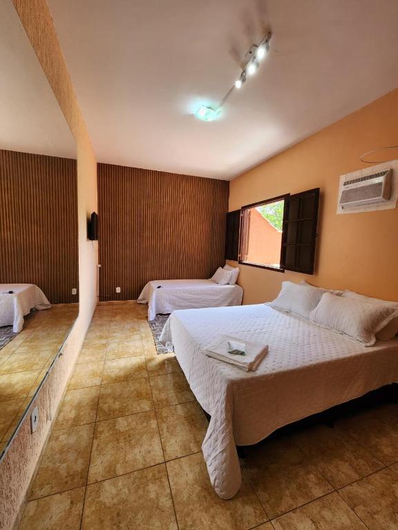 a large bedroom with two beds and a window at Espaço Sunshine in Saquarema