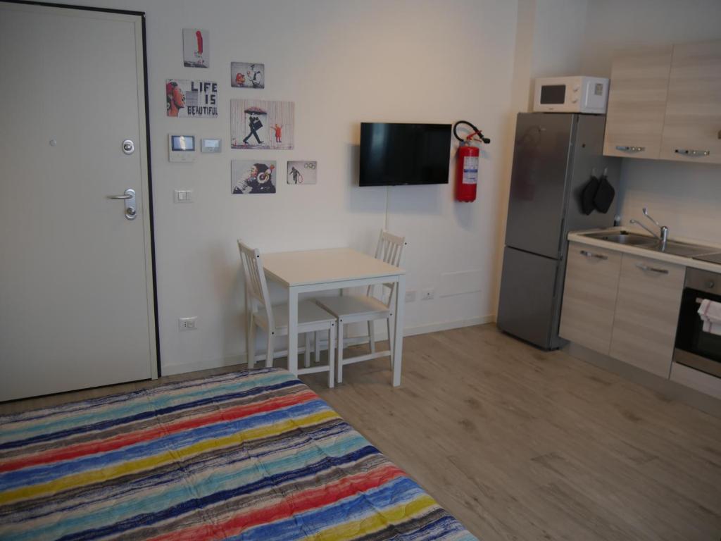 a small kitchen with a table and a refrigerator at Guest House Il Colibri' in Bologna
