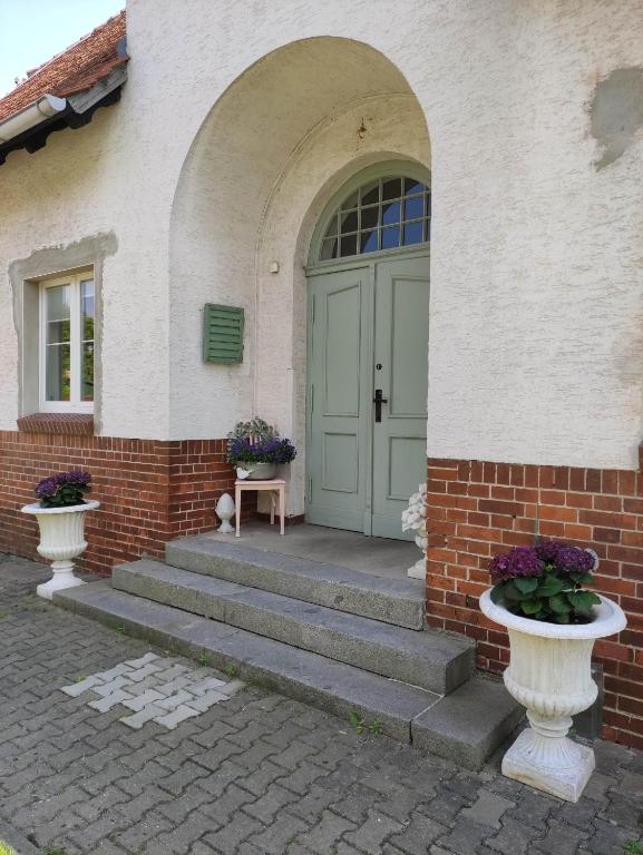 a front door of a house with stairs and flowers at Alte Schule Ragow in Ragow