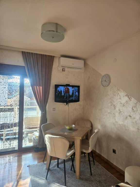 a dining room with a table and a tv on the wall at MakiLen in Vrnjačka Banja