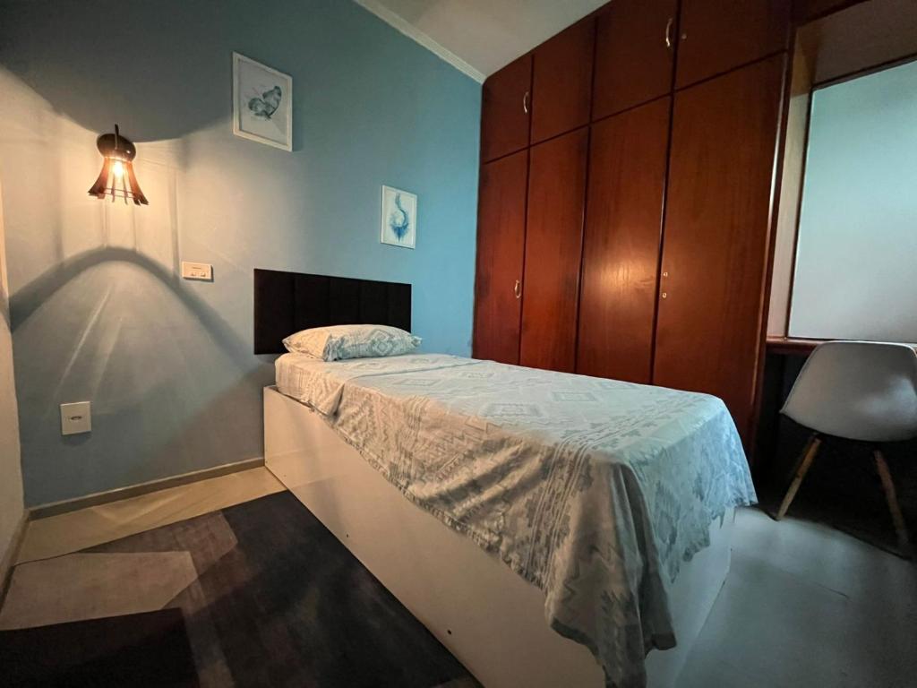 ein kleines Schlafzimmer mit einem Bett und einem Stuhl in der Unterkunft Ritz Hostel in Araçatuba