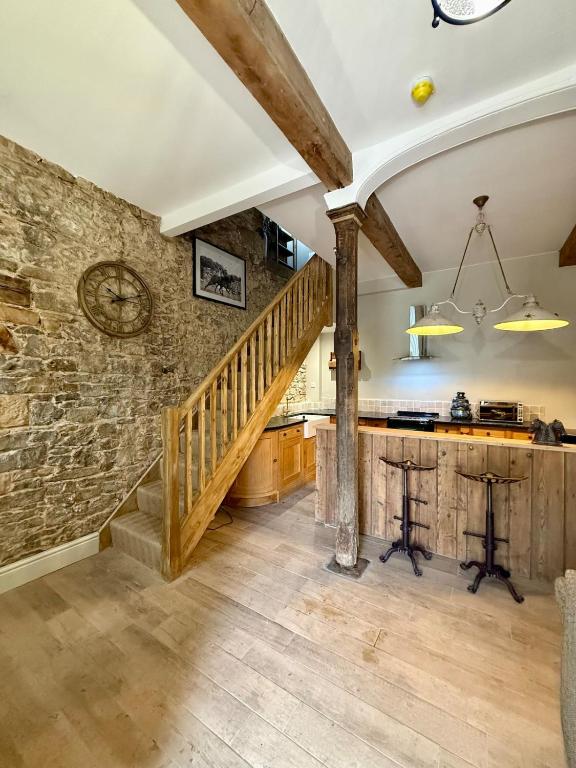 a kitchen with a staircase and a stone wall at The old stables at flass in Maulds Meaburn
