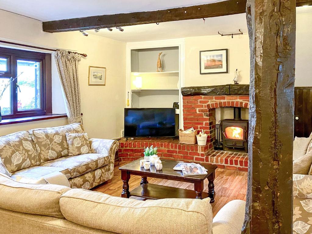 a living room with couches and a fireplace at Brook House 2 - Uk31043 in Bassenthwaite