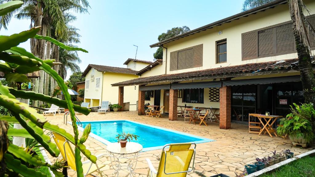 a swimming pool in front of a house at Recanto da Tuca in Socorro